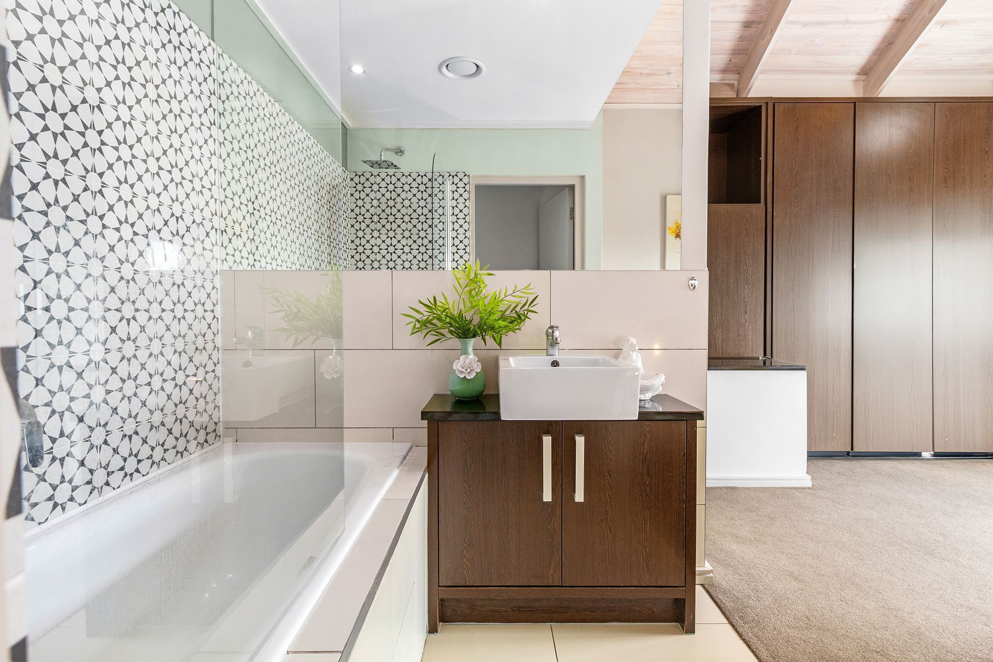 A modern bathroom with a bathtub, a sink, and a cabinet.