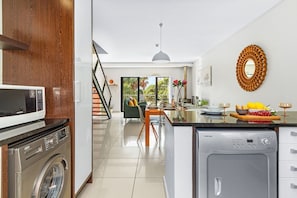 A modern kitchen with a washing machine, a microwave, and a dishwasher.