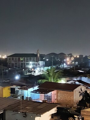 Vista nocturna de una zona residencial con edificios, una mezquita y farolas.