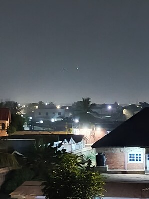 Vista nocturna de una zona residencial con casas, farolas y cielo despejado.