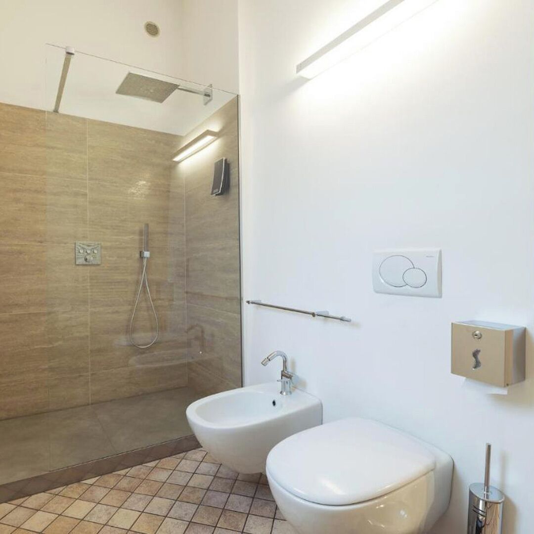 Ein modernes Badezimmer mit einer Duschkabine, einem Bidet und einer Toilette.