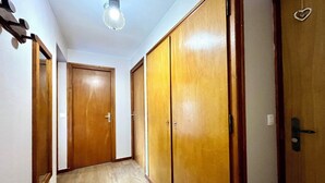 A hallway with wooden doors, a light fixture, and a heart-shaped decoration on one door.