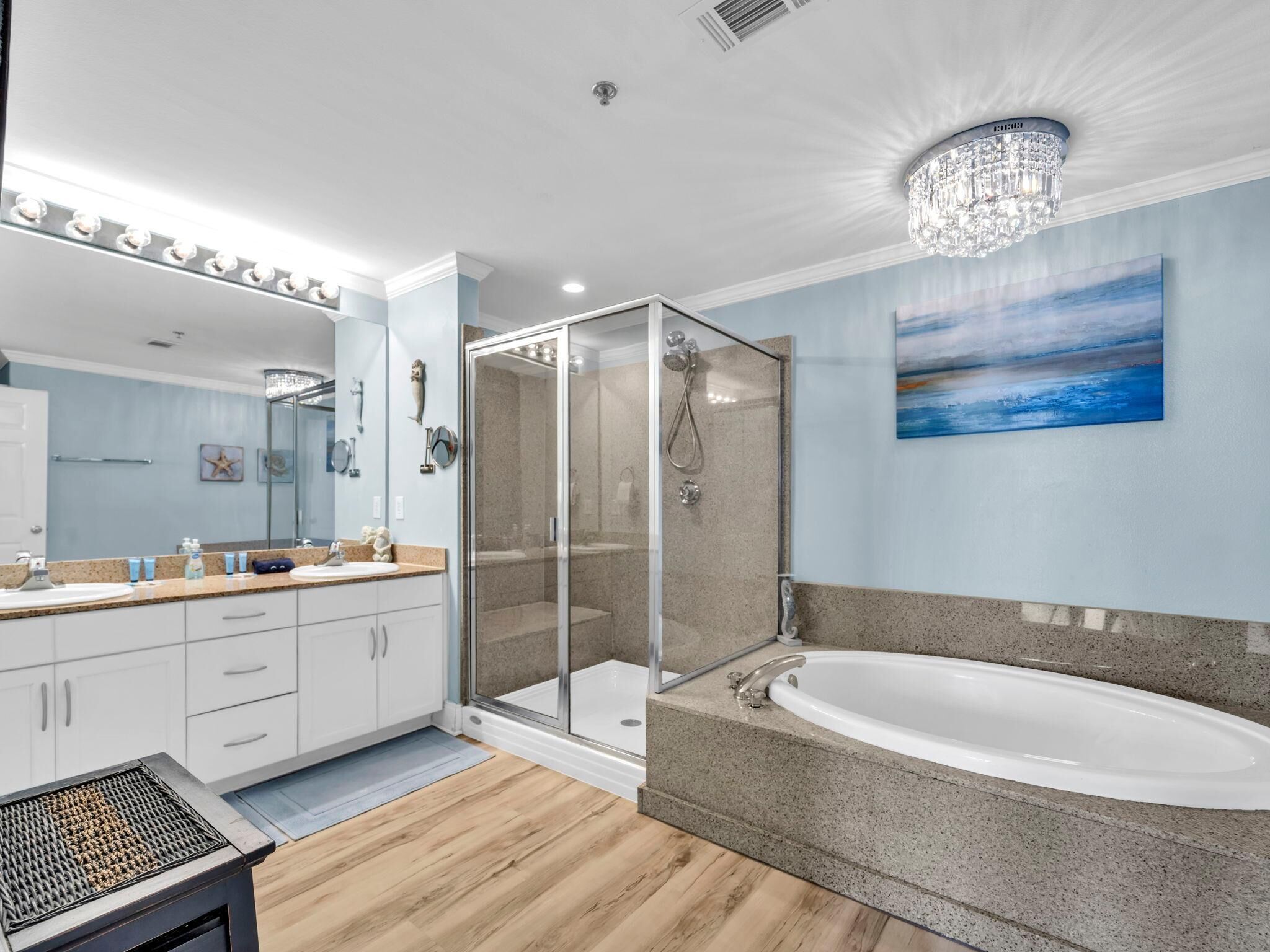 Un baño moderno con ducha envuelta en vidrio, una bañera amplia y un tocador con espejo.