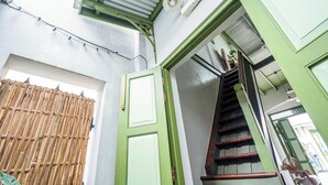 Un escalier avec une rampe en bois et un cadre de porte vert.