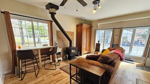 Un salon chaleureux avec un plancher en bois, un canapé, une table basse et une cheminée.