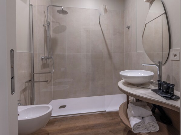 A modern bathroom with a glass-enclosed shower, a white sink, and a wooden vanity. - Soul of Trento San Martino (Trento)