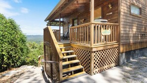 A wooden cabin with a deck, a 'Welcome' sign, and a '103 The Fishing Moose' sign. - River View, Sleeps 6, Hot Tub (Carroll County)