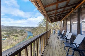 Une terrasse en bois avec des sièges extérieurs et une vue sur une rivière.