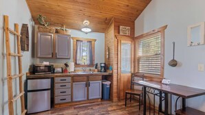 A compact kitchen with wooden cabinets, a microwave, and a sink. - Cabin w/King Bed, Jacuzzi + View (Carroll County)
