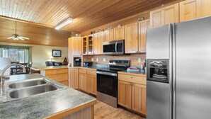 Una cocina moderna con armarios de madera, electrodomésticos de acero inoxidable y encimera de granito.