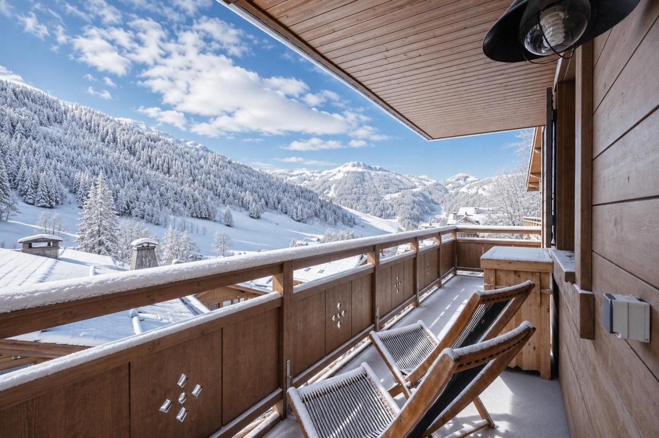 A wooden balcony with a view of a snow-covered mountain landscape.