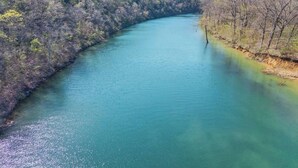 Un río serpentea por un valle arbolado bajo un cielo despejado.