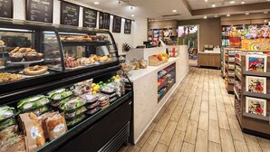 Eine Bäckereitheke mit verschiedenen Backwaren und eine Feinkostabteilung mit verpackten Sandwiches.