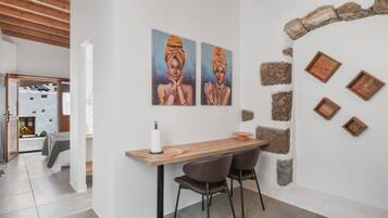 Et moderne interiør med et træbord, to stole og kunst på væggen.