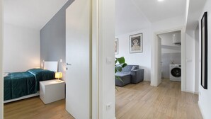 Eine moderne Wohnung mit einem Schlafzimmer, einem Wohnbereich mit einer Couch und einem Waschraum.