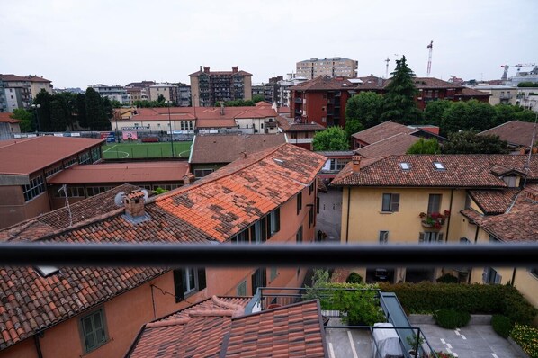 A residential area with terracotta-tiled roofs, a soccer field, and multi-story buildings.