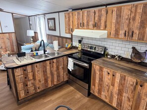 A kitchen with wooden cabinets, a stainless steel stove, and a sink.