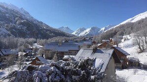 Een bergresort met besneeuwde gebouwen en een helder uitzicht op de omliggende toppen.