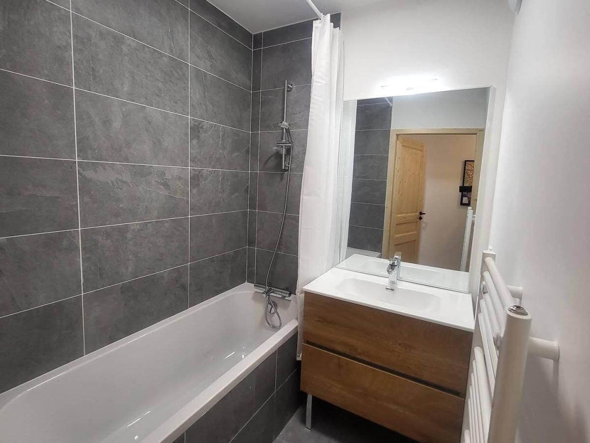 Une salle de bain équipée d’une baignoire, d’une douche et d’un meuble-lavabo avec un miroir.