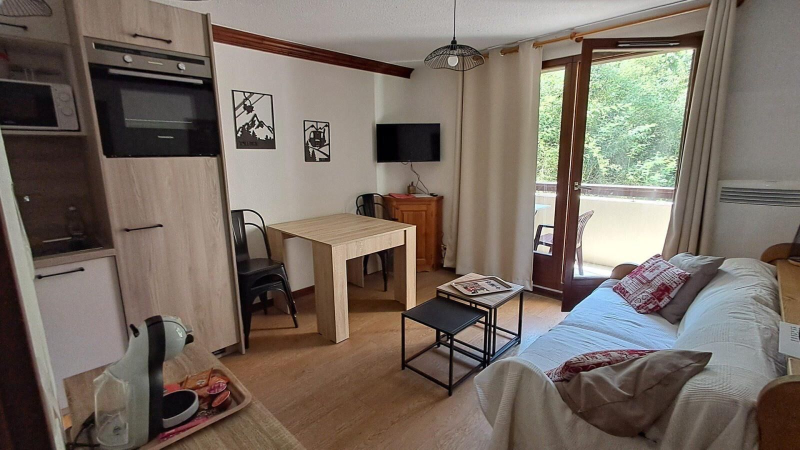 Une petite chambre comprenant un lit, un bureau et une kitchenette.