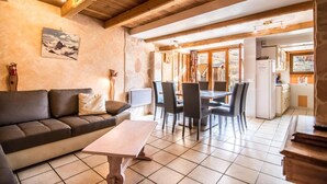 A cozy living room with a sofa, a coffee table, and a dining area with chairs and a table. - 1st floor, terrace, tv, ski locker, 85m², Valloire (Valloire)
