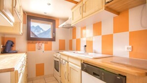A compact kitchen with a window, a coffee machine, a dishwasher, and a stove. - 1st floor, terrace, tv, ski locker, 85m², Valloire (Valloire)