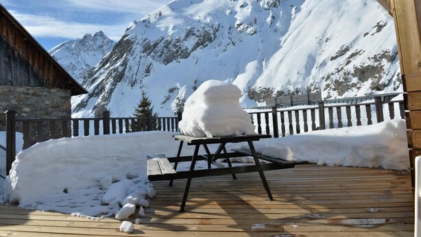 A wooden deck with a snow-covered table and a snowman sculpture. - 1st floor, terrace, tv, ski locker, 85m², Valloire (Valloire)