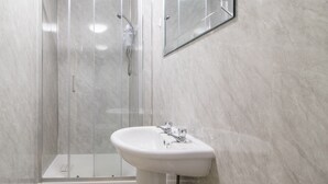 A modern bathroom with a glass-enclosed shower, a pedestal sink, and a mirror on the wall. - Pass the Keys | Cosy in Fabulous West End (Glasgow)