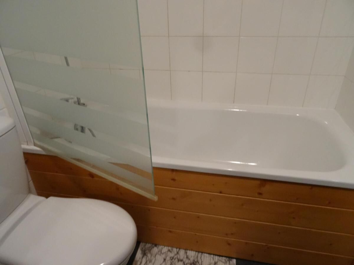 Ein Badezimmer mit einer weißen Badewanne, einer Duschkabine aus Glas und einem weißen WC.