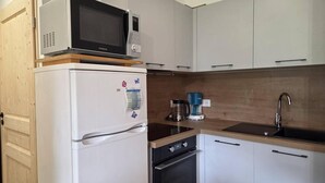 A compact kitchen with a refrigerator, microwave, coffee maker, and a sink. - 15m from ski slopes, 1st floor, view ski slopes, balcony, tv, ski locker, 47m², Valmorel (Valmorel)