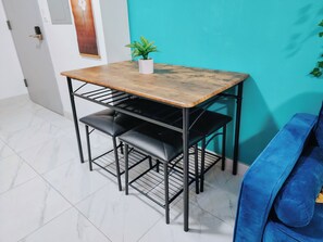 A small dining area with a wooden table and black metal chairs.