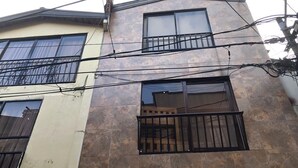 Un edificio de varios pisos con balcones y fachada de tejas.