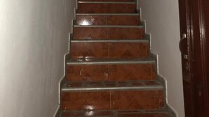 Una escalera con barandilla que lleva a una puerta con un letrero encima.