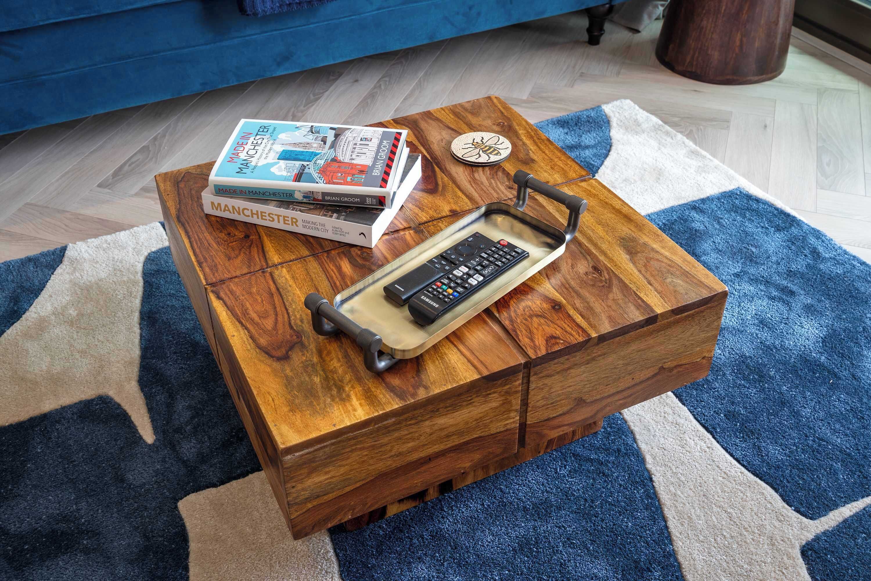 Ein Holztisch mit Fernbedienung und Büchern.