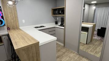 A modern kitchen with a wooden island, built-in appliances, and pendant lighting.