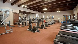 A gym with treadmills, elliptical machines, and weight equipment.