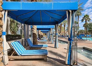 Un espace aménagé au bord de la piscine, avec des chaises longues et un coin salon abrité.