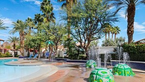 A swimming pool with a water feature, surrounded by palm trees and lounge chairs. - Stylish Desert King Room w/ Balcony + Pool View (La Quinta)
