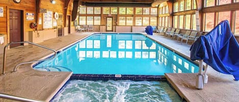 A pool area with a hot tub, wooden walls, and a clock.