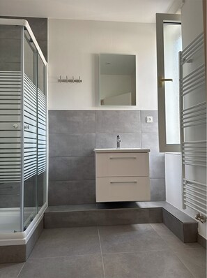 Comfort dubbelrum - utsikt mot staden | Badrum | Dusch, hårtork, handdukar och toalettpapper