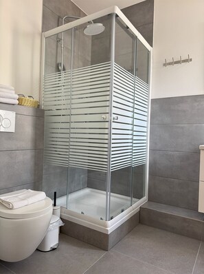 Habitación doble Confort, vista a la ciudad | Baño | Regadera, secadora de cabello, toallas, papel de baño 