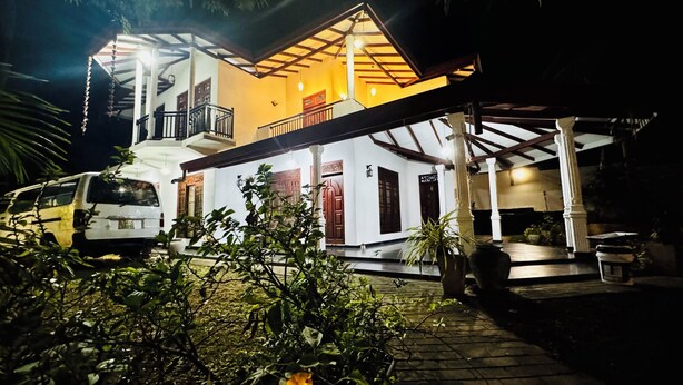 A two-story house with a balcony and a covered porch. - Feel at Home While You Travel (Tangalle)