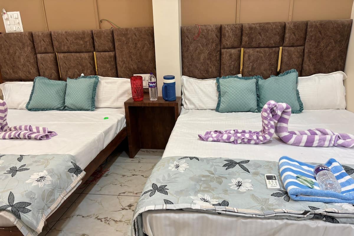 Two twin beds with headboards, a nightstand, and a bathroom mirror.
