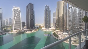 A high-rise building with a curved facade overlooking a marina with boats. - Vibrant Studio in JLT Sleeps 4 With Lake Views (Dubai)