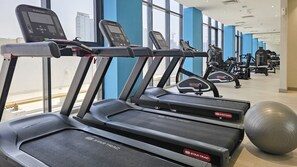 A gym with multiple treadmills, exercise balls, and weight machines. - Meydan Apartment Sleeps 2 With Huge Balcony (Dubai)