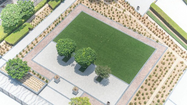An aerial view of a landscaped area with a central grassy lawn, surrounded by pathways and bordered by neatly arranged shrubs and trees. - Downtown Dubai Stunning Apartment for 4 People (Dubai)
