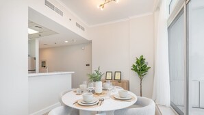 Un espace repas moderne avec une table ronde pour quatre personnes, entourée de chaises à revêtement gris.