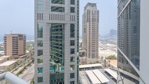 Un immeuble de grande hauteur, doté de nombreux étages, de grandes fenêtres et offrant une vue sur un paysage urbain comprenant d’autres bâtiments et une étendue d’eau.