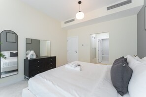 A modern bedroom with a bed, dresser, and a mirror. - Dubai Marina Sleeps 4 in the Centre of the Marina (Dubai)