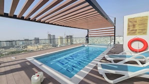 A rooftop swimming pool with a city view, a covered seating area, and a lifebuoy. - JVC Studio for 3 People With Swimming Pool (Dubai)